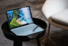 Surface Pro on a black table with a beach scene displayed on the screen.