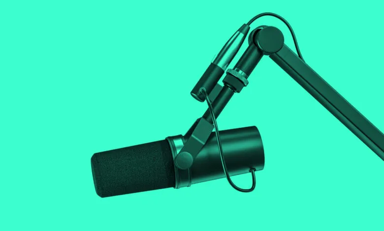 Studio microphone on boom arm against a vibrant teal background.