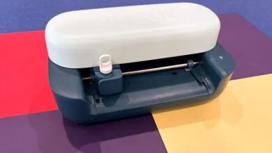 Cricut Joy 2 cutting machine on colorful paper background.