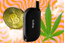 Black Gudtrip vape pen with Bitcoin and cannabis leaf on psychedelic background.