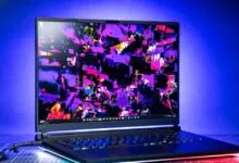 Asus ROG Strix Scar 18 laptop with vibrant abstract art on screen.