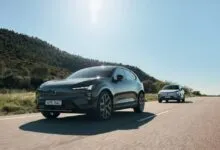 Two Volvo EX30 electric SUVs driving on a sunny road.