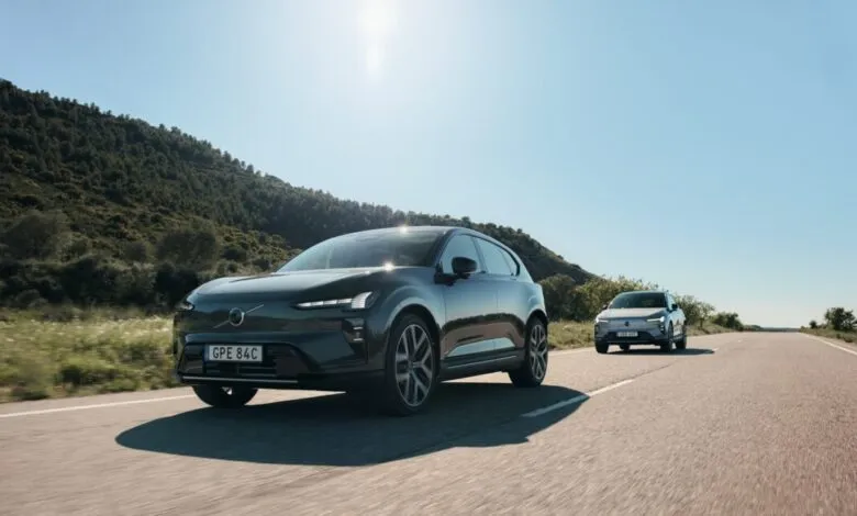 Two Volvo EX30 electric SUVs driving on a sunny road.