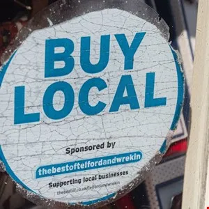 "Buy Local" sticker with blue text on a white background, promoting local businesses.