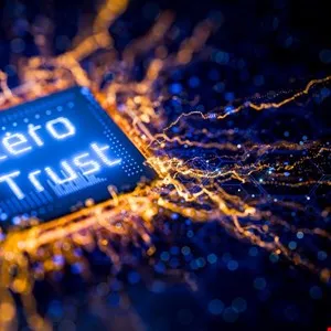 Close-up of a microchip with 'Zero Trust' illuminated in blue, surrounded by golden light trails.