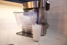 Countertop ice maker filling glass with nugget ice.