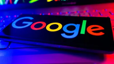 Google logo displayed on a phone screen resting on a laptop keyboard.