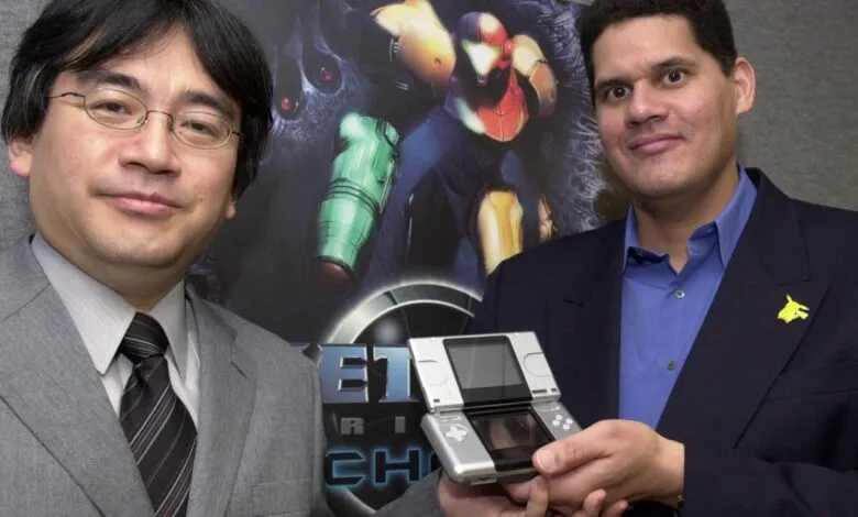 Shigeru Miyamoto and Reggie Fils-Aimé holding a Nintendo DS.