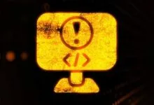 Computer monitor icon with exclamation point and code symbols, indicating an error.