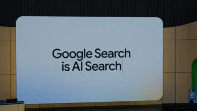 Large screen displays 'Google Search is AI Search' at a conference.