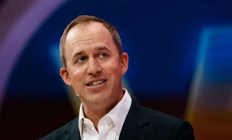 Headshot of a man in a suit speaking at a conference.