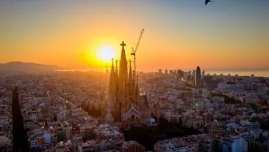 Sagrada Familia cathedral in Barcelona at sunrise, construction crane visible.