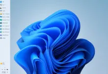 Windows 11 desktop with blue abstract wallpaper and left-side menu.