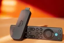 Amazon Fire TV Stick 4K Max (2023) and remote on a light orange surface.