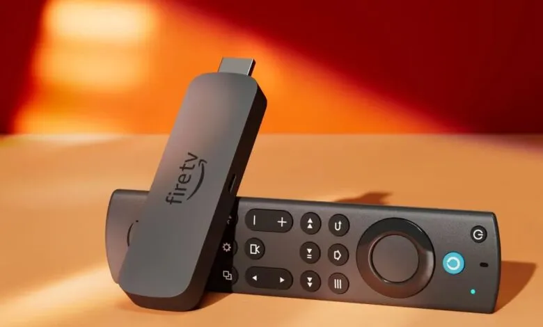 Amazon Fire TV Stick 4K Max (2023) and remote on a light orange surface.