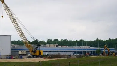 Construction site with a large yellow crane and building under construction.