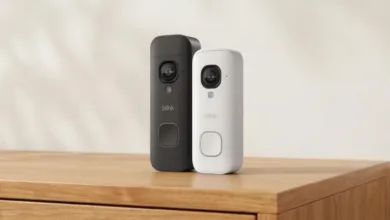 Two Blink 2K video doorbells, one black and one white, on a wooden surface.