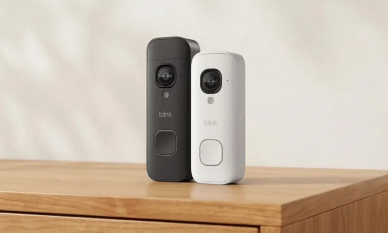 Two Blink 2K video doorbells, one black and one white, on a wooden surface.