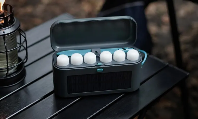 BioLite SiteLights in case on table with lantern, ready for camping.
