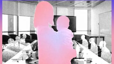 Silhouette of mother holding baby in office meeting room.