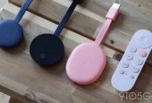 Three Google Chromecasts and a remote on a wooden surface.