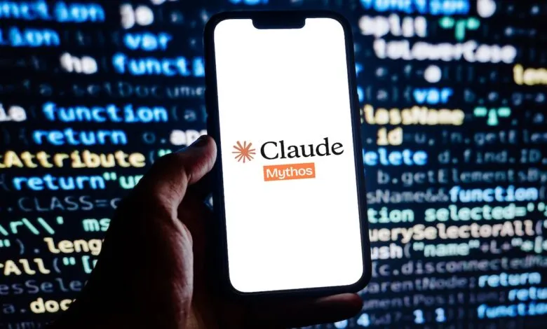 Hand holds phone displaying Claude-Mythos logo against code background.