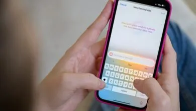 Person using Genmoji feature on iPhone with pink case.
