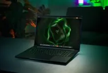 Razer Blade laptop with green glowing keyboard and screen display.