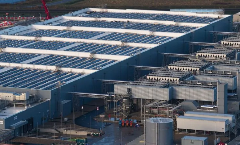 Large data center with solar panels on roof and cooling systems.