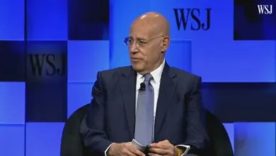 Peter Arnell at WSJ event, wearing suit and glasses.
