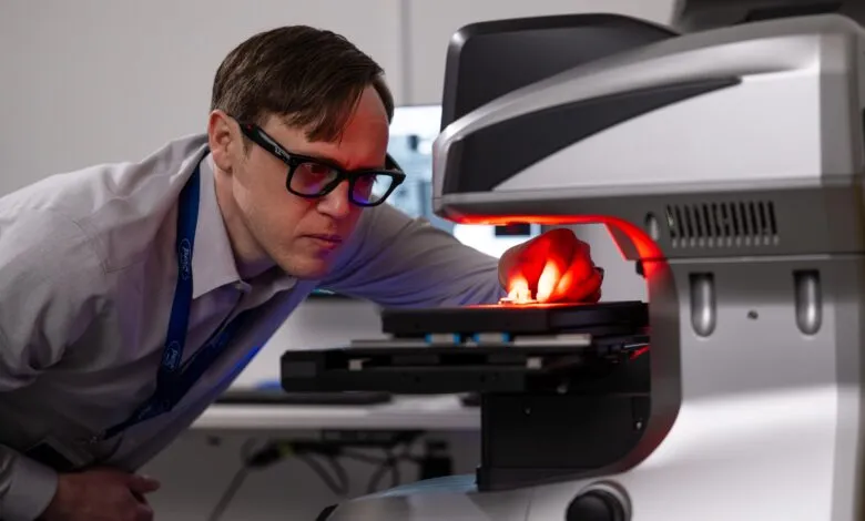 Ford engineer examines part with advanced metrology equipment.