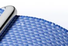 Close-up of a woven blue and white watch band with a silver connector.