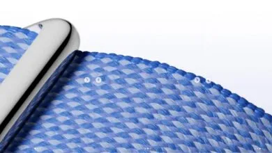 Close-up of a woven blue and white watch band with a silver connector.