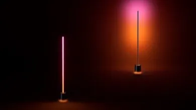 Two modern floor lamps with gradient pink and orange lighting in a dark room.
