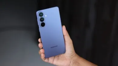 Hand holding a purple Samsung Galaxy smartphone with three rear cameras.
