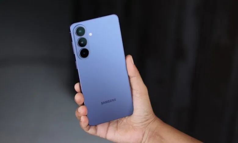 Hand holding a purple Samsung Galaxy smartphone with three rear cameras.