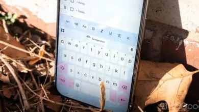Smartphone displaying Gboard keyboard app on a task list, outdoors.