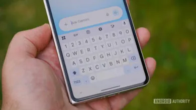 Hand holding phone with Gemini AI interface open on the screen.