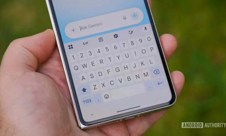 Hand holding phone with Gemini AI interface open on the screen.
