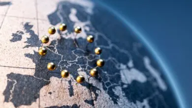 Globe map of Europe with golden pins forming EU flag stars.