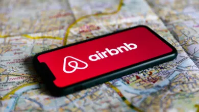 Smartphone displaying Airbnb logo on a map, suggesting travel planning.