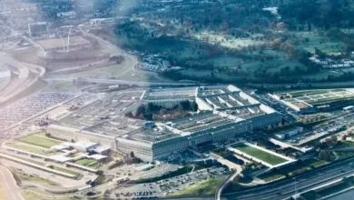 Aerial view of the Pentagon building, surrounded by roads, parking lots, and greenery.