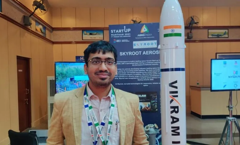 Pawan Kumar Chandana, CEO of Skyroot Aerospace, stands next to a model rocket.