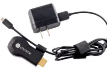 Google Chromecast dongle, power adapter, and cable on white background.