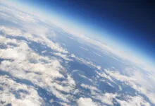 Aerial view of Earth's horizon with clouds and blue atmosphere.