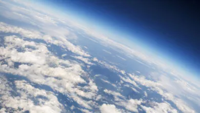 Aerial view of Earth's horizon with clouds and blue atmosphere.