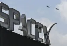 SpaceX sign with two jets flying in the sky above.