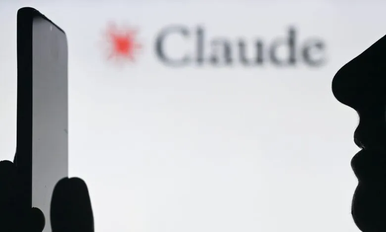 Silhouette of person using phone with 'Claude' logo in background.