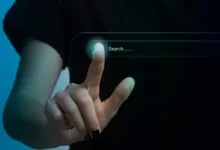 Finger touching a virtual search bar with a magnifying glass icon.