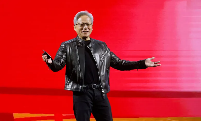 Jensen Huang, NVIDIA CEO, presents on stage with a red backdrop.